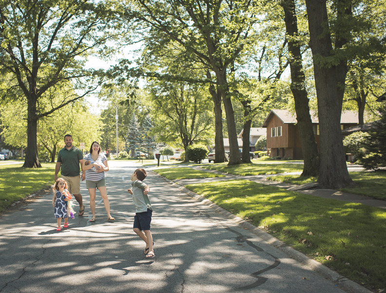 family skipping down street through neighborhood, filled with joy