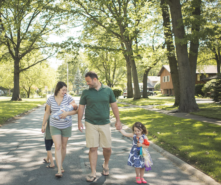 family strolling down neighborhood street, connecting in joy 