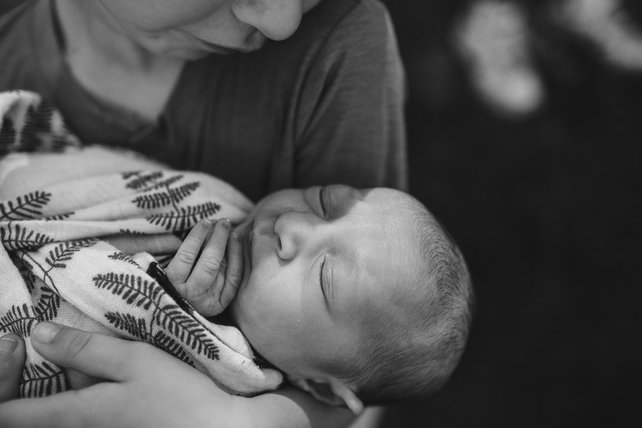 brother cradling newborn baby sister; powerful, connection, black and white 