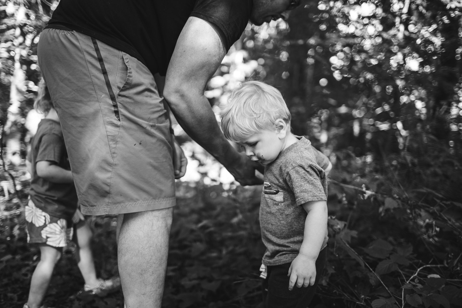 Boy holding hands with father collecting blackberries 