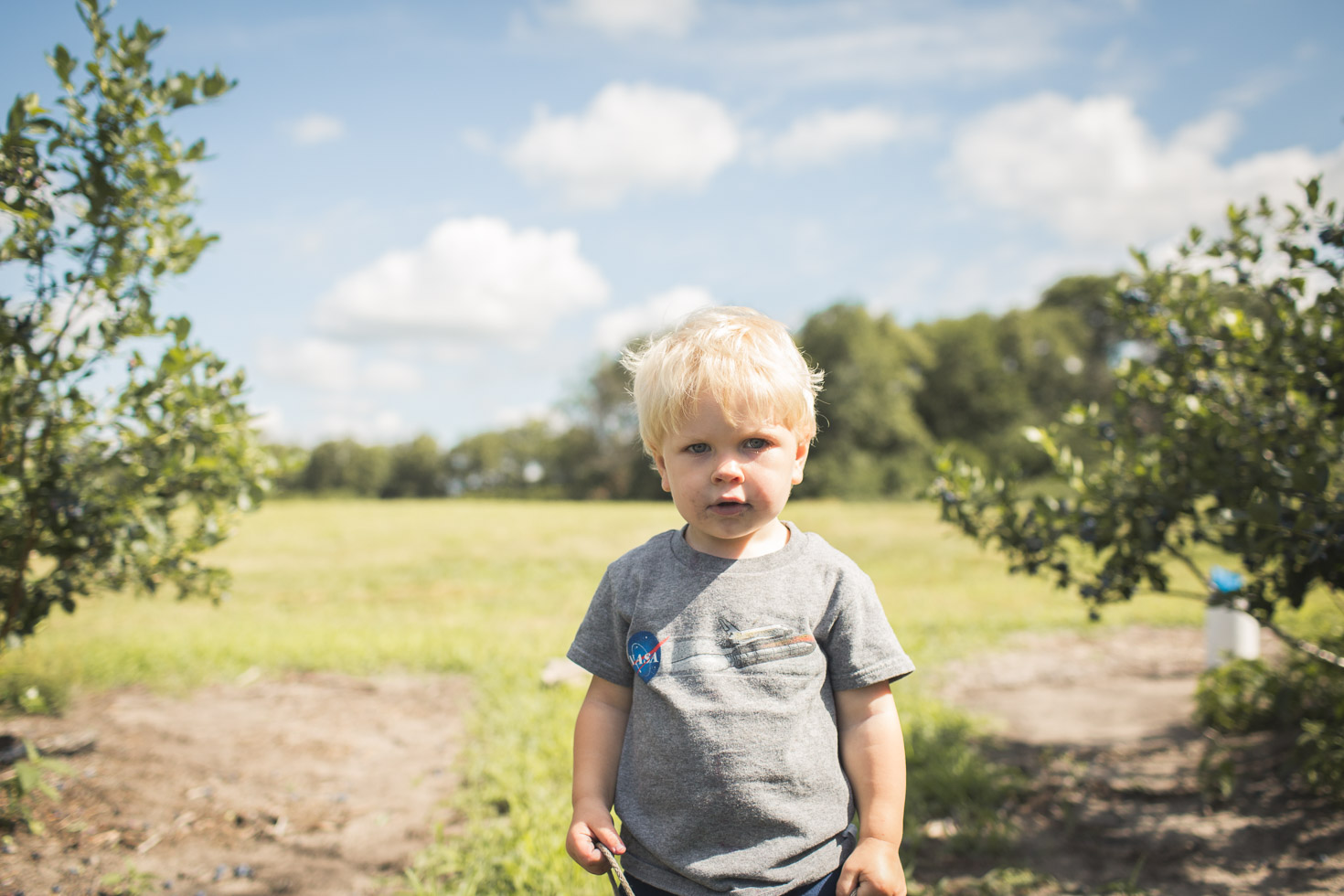 boy looking into camera at blueberry farm, connected and powerful