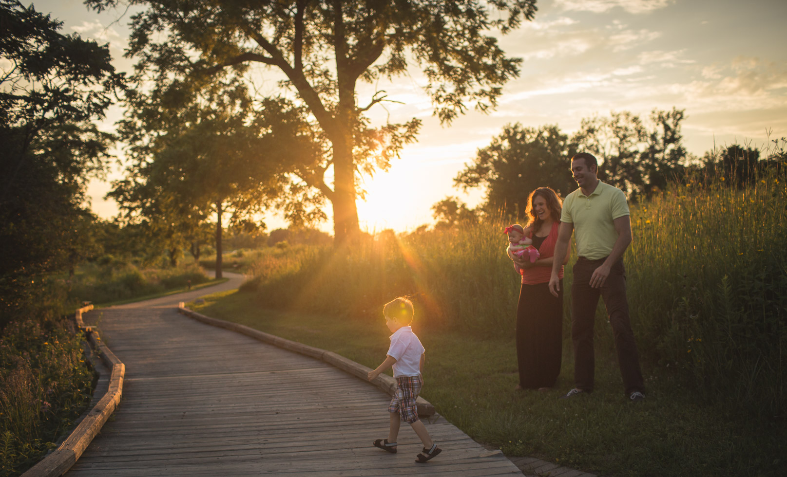 boy walking through golden light with family adoring, Coffee Creek Watershed Preserve