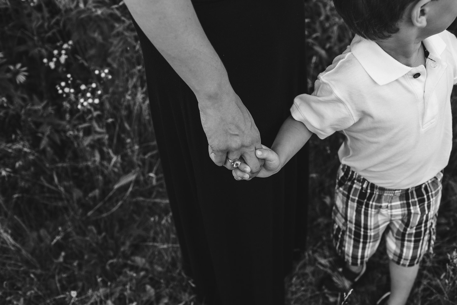 Detail portrait of mother and son holding hands, black and white, connection, emotional storytelling