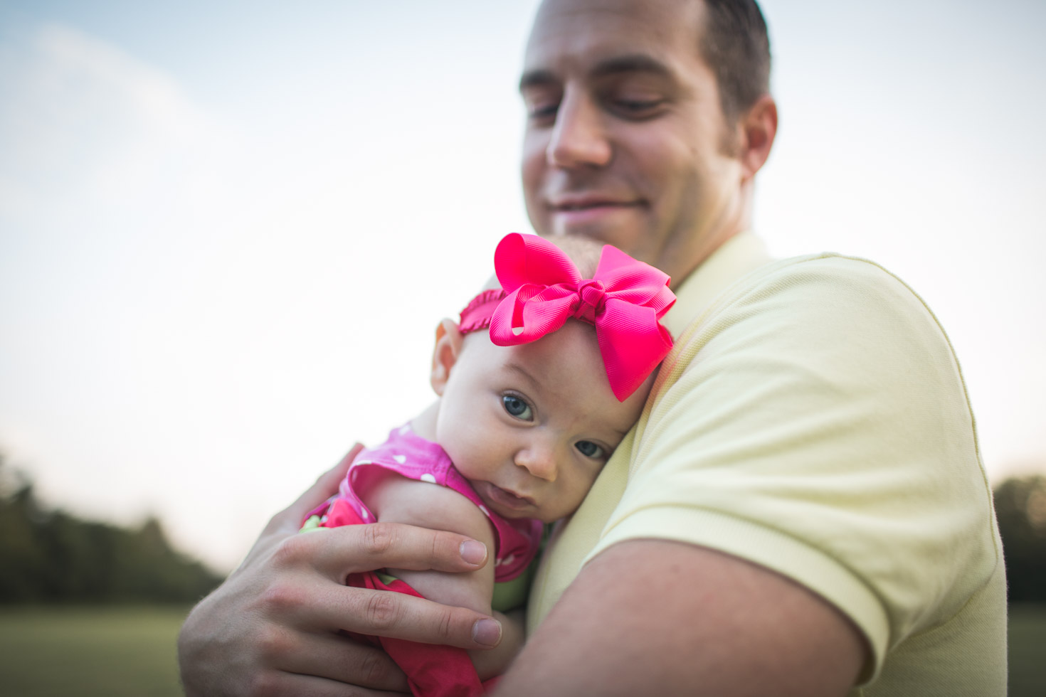 father embracing newborn daughter in his arms, connection, wide angle