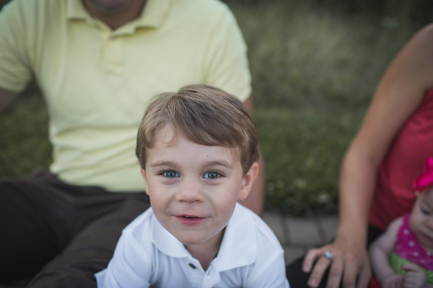 wide angle portrait of boy with his family, in golden evening sunlight