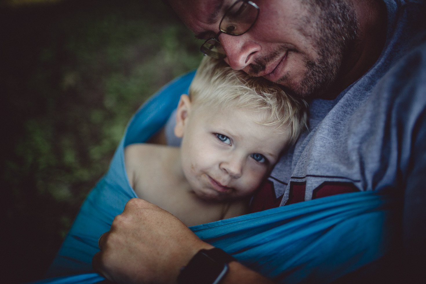 Portrait of son resting in fathers arms, shadow light, natural light 