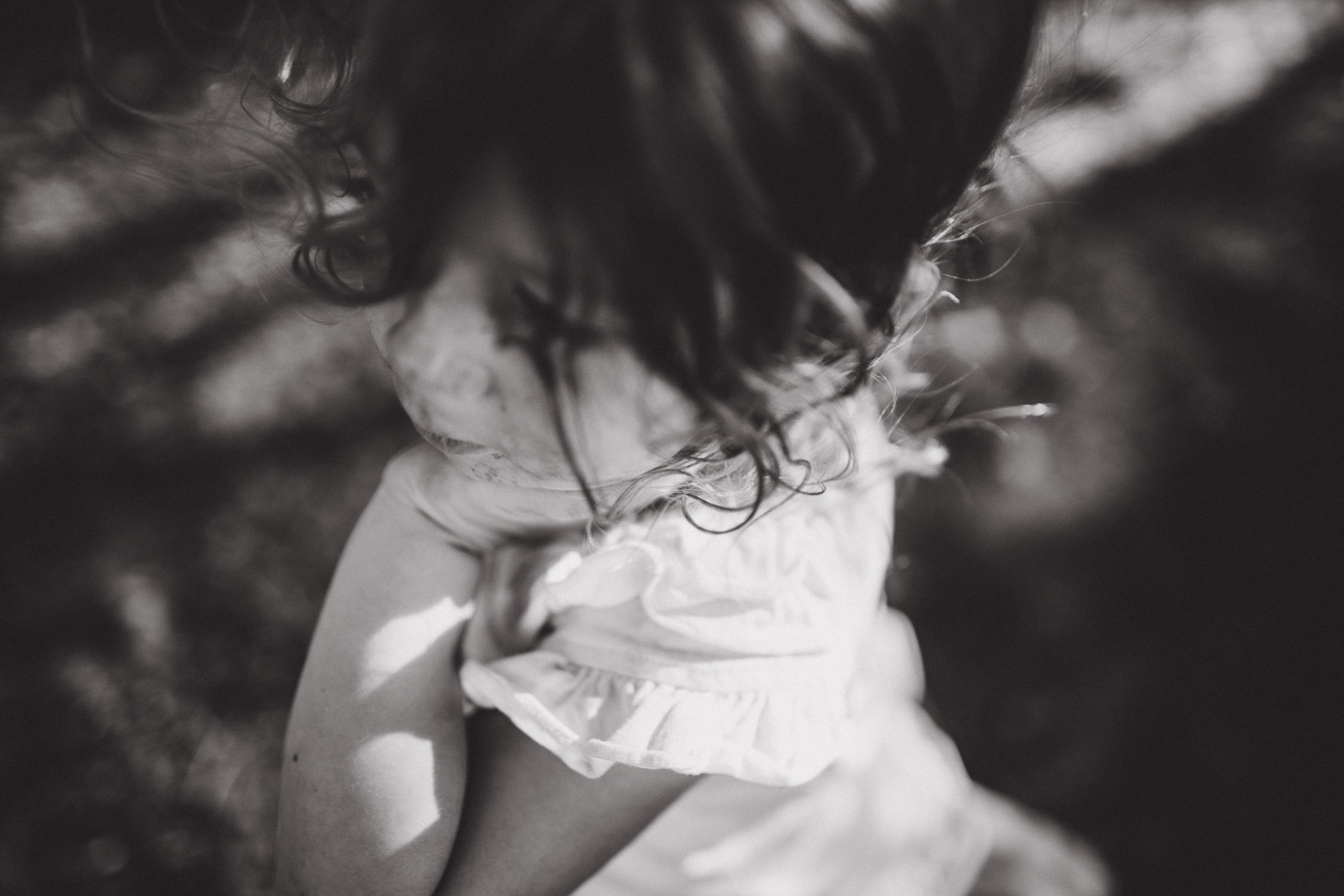 Wide angle out of focus portrait of girl with hand under chin, black and white 