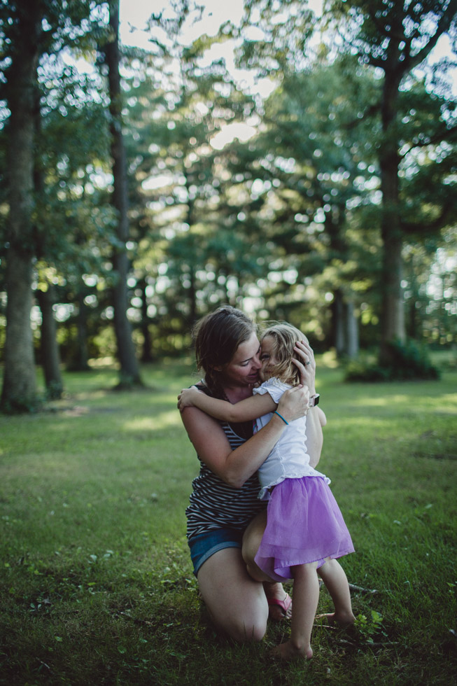 mother tenderly embracing child in forest