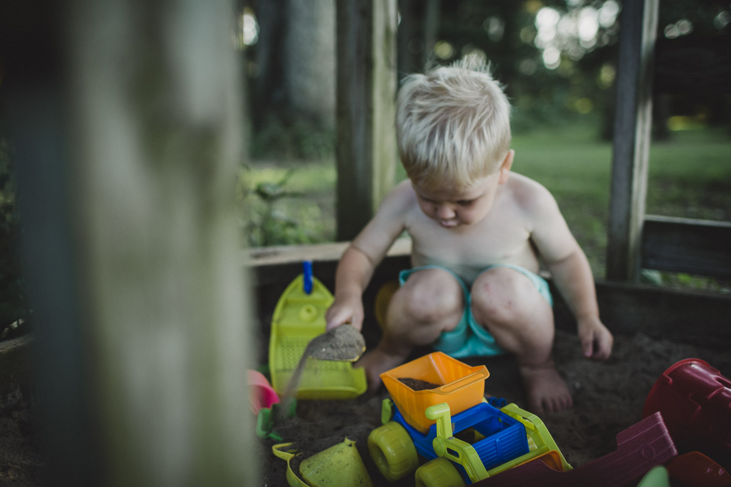 A boy playing with his truck in the sand