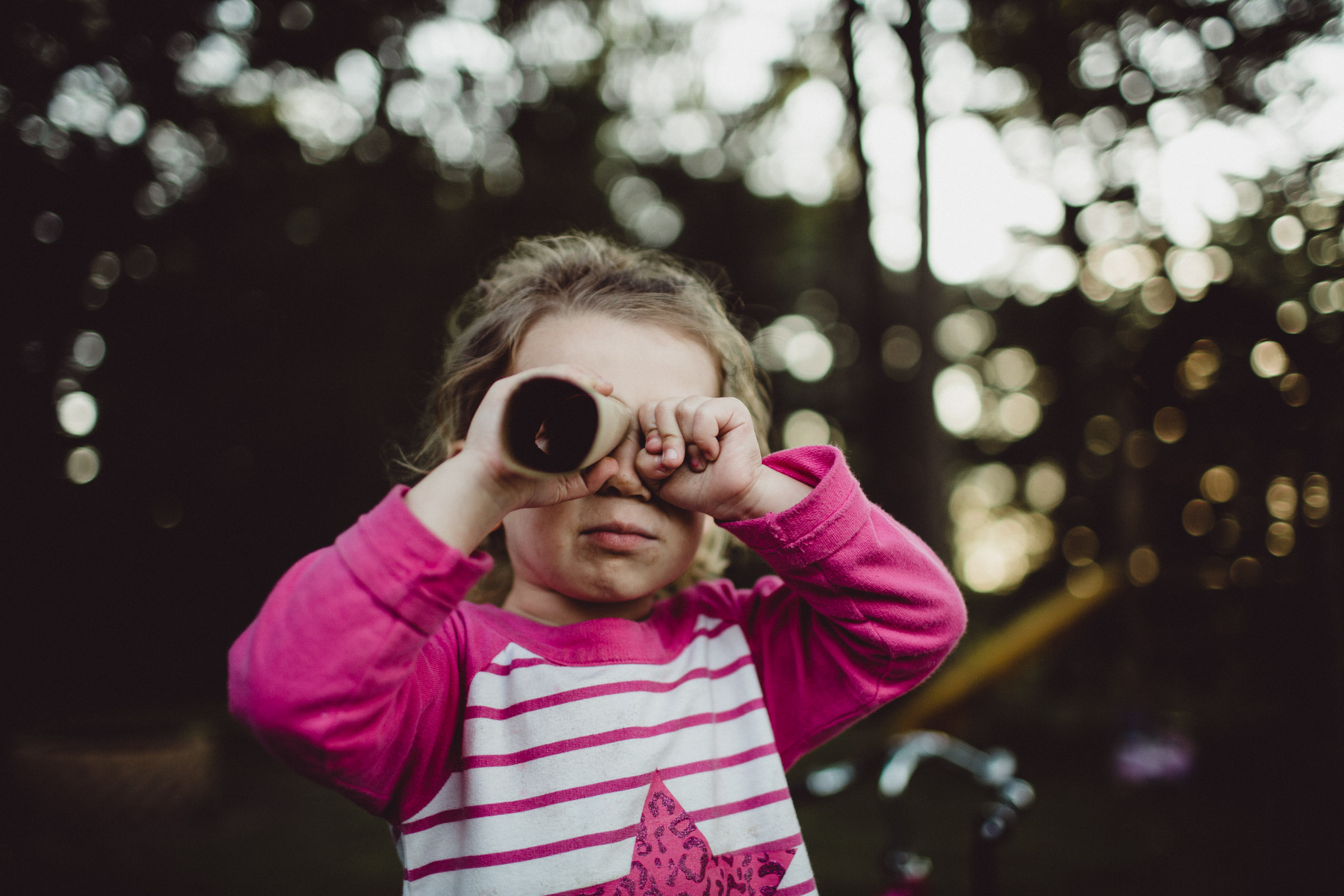 Portrait of girl looking through toilet paper role on an adventure 