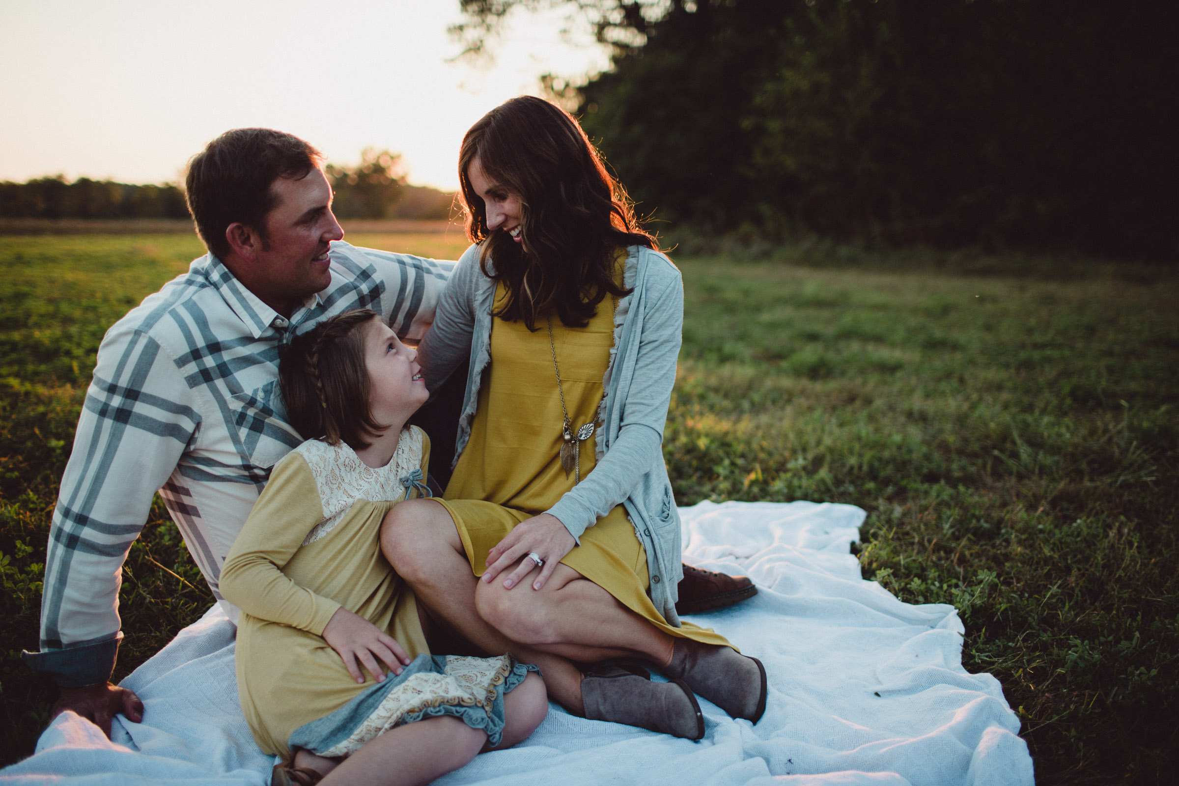 parents seated and loving on their daughter 