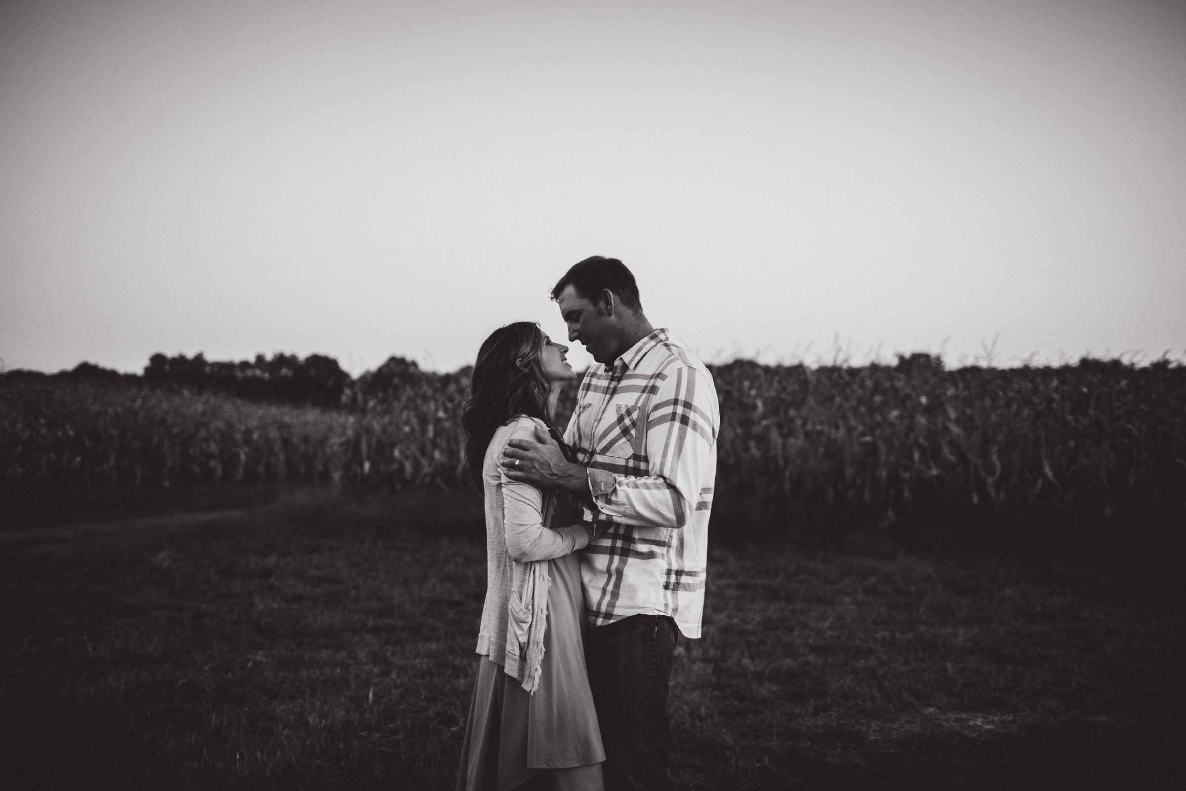 husband and wife enjoying each other in a field 