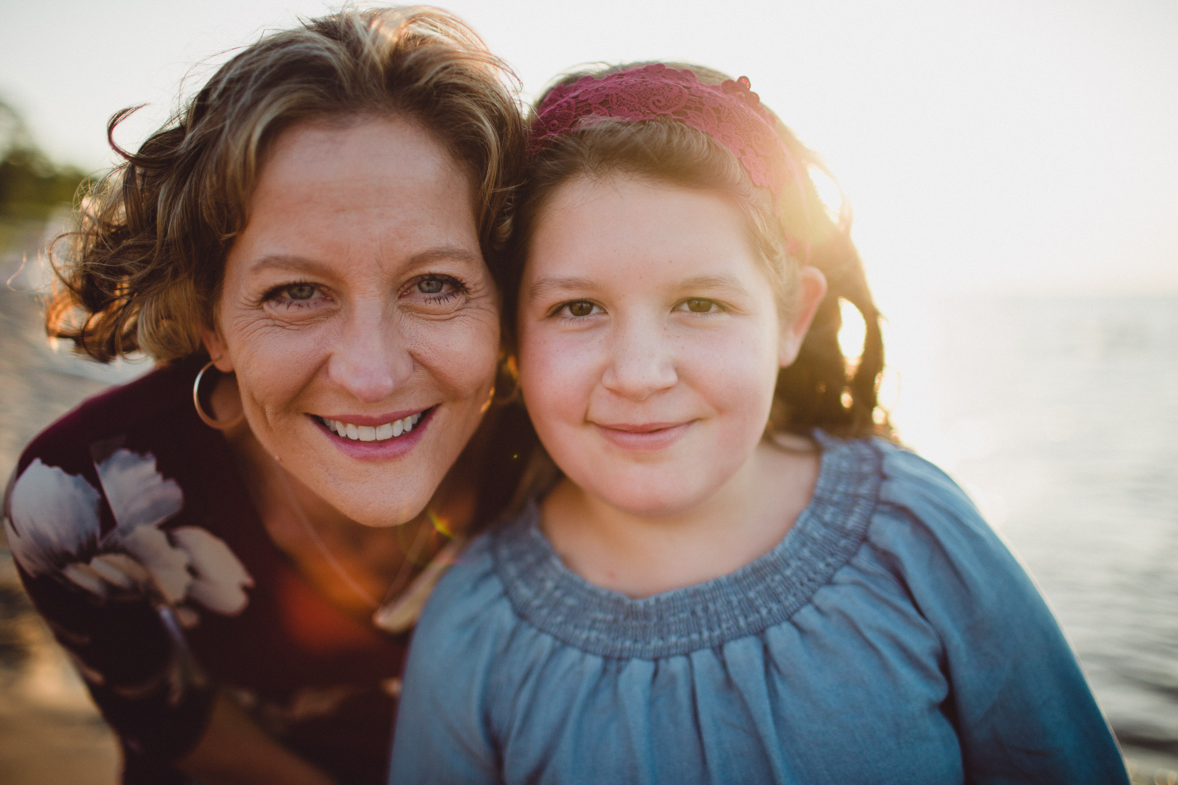 backlit portrait of mother and daughter on the beach 