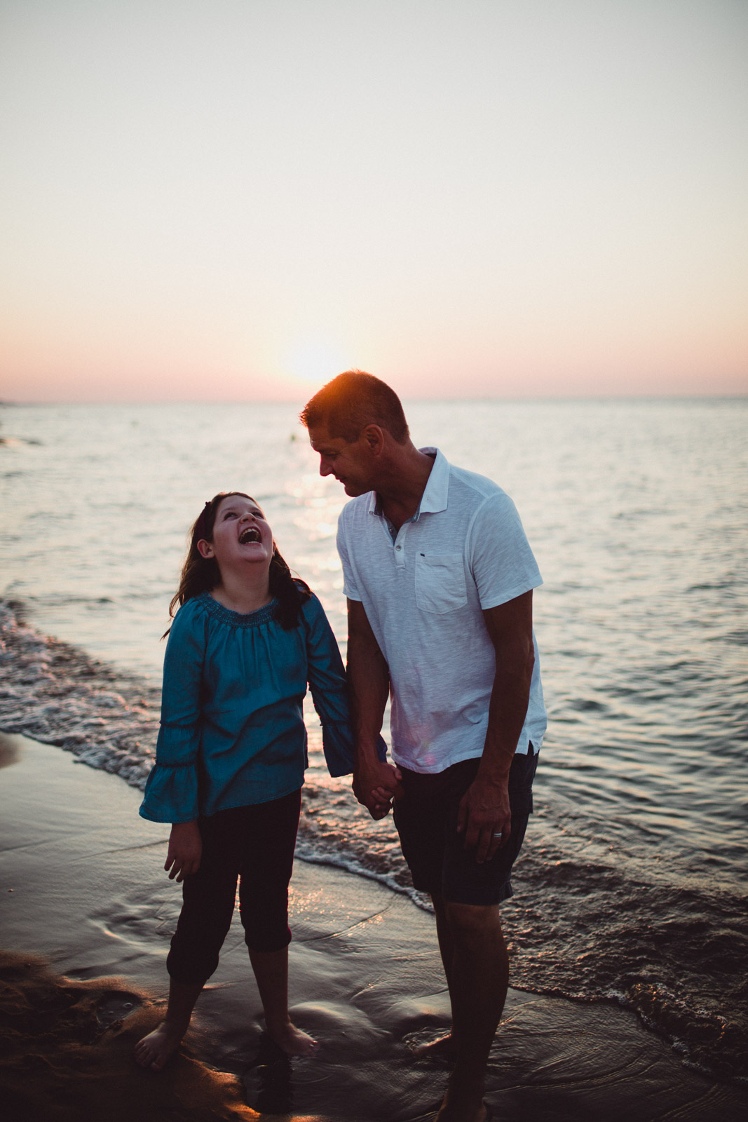 daughter laughing with her father on the beach 