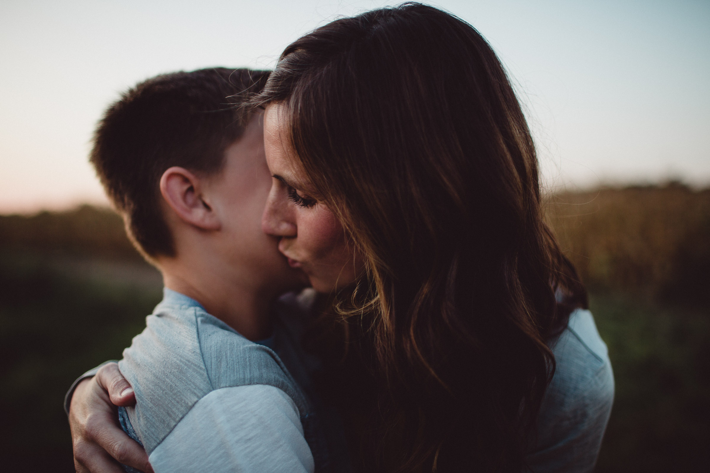 mother kissing son on the cheek 