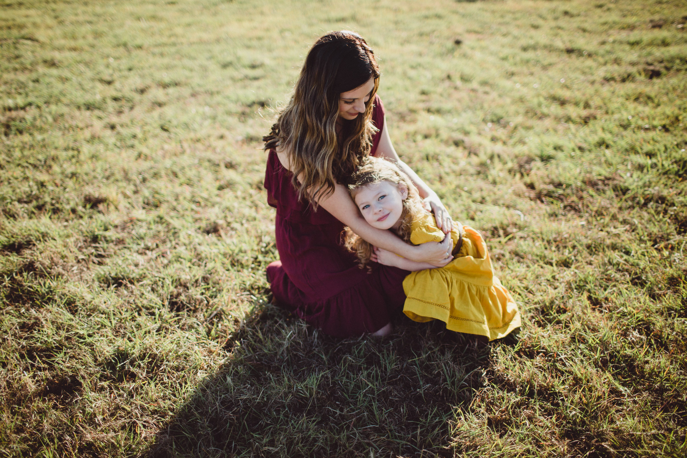 mother sitting in grass with daughter 