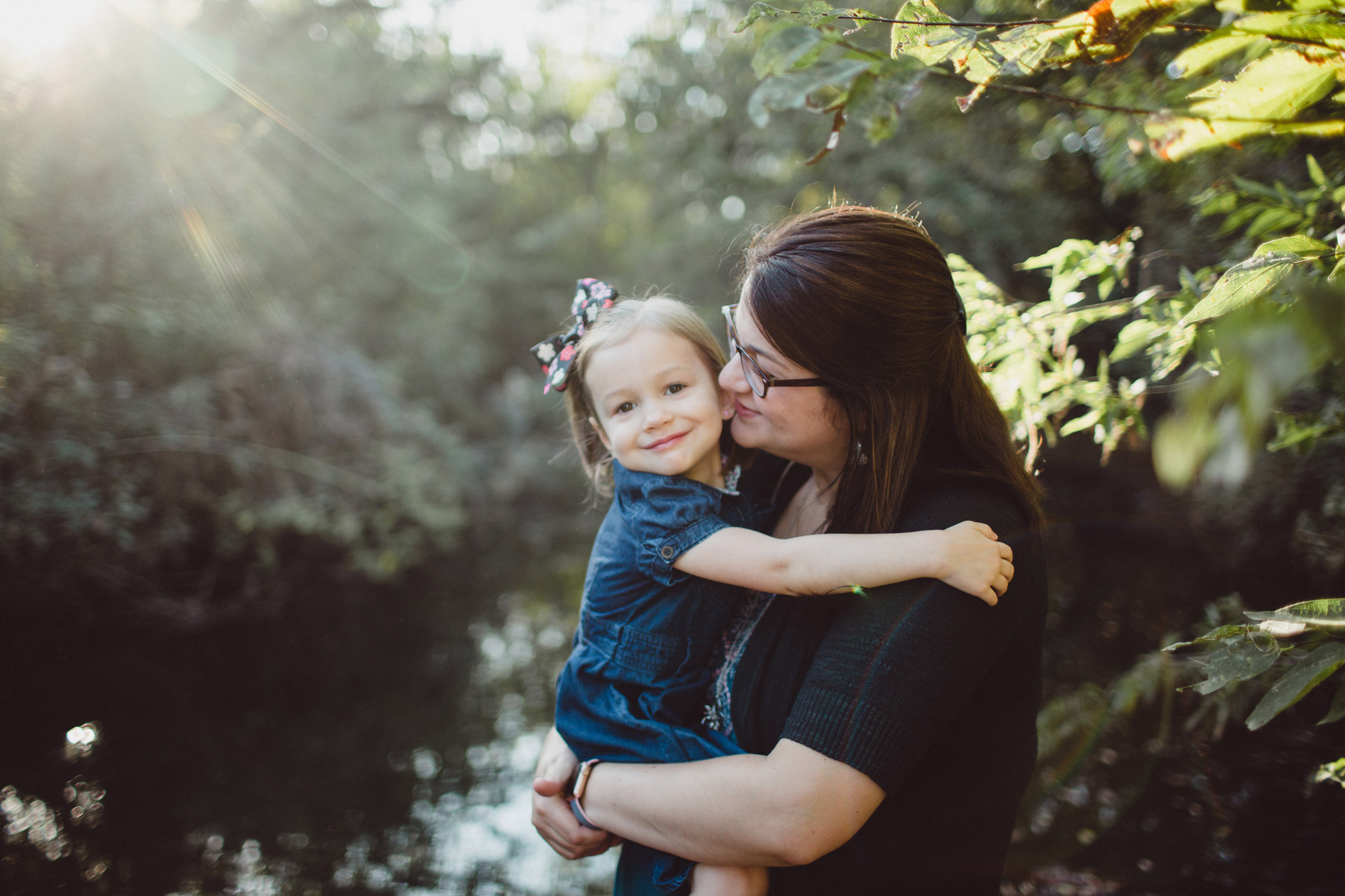 mother and daughter snuggling in warm of morning rays 