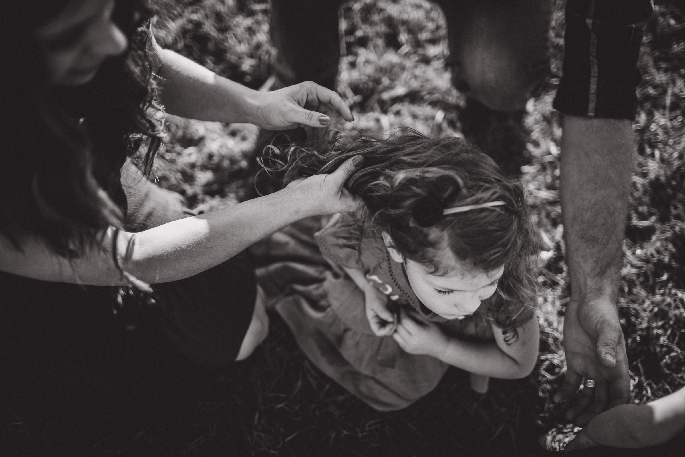 black and white portrait of mother streaming her hands through her daughters hair 