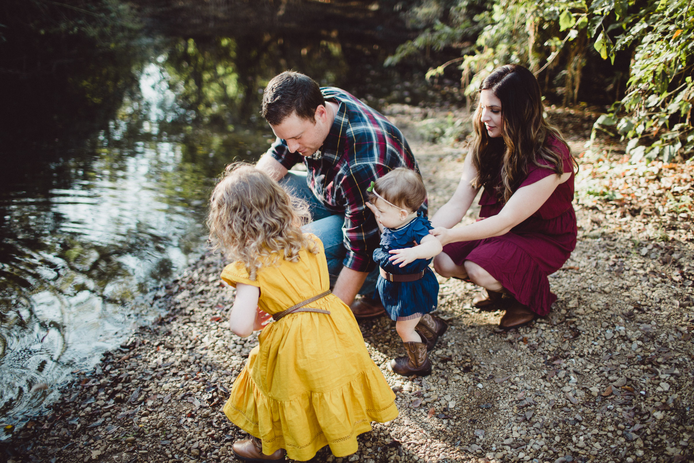 family interacting beside a creek 