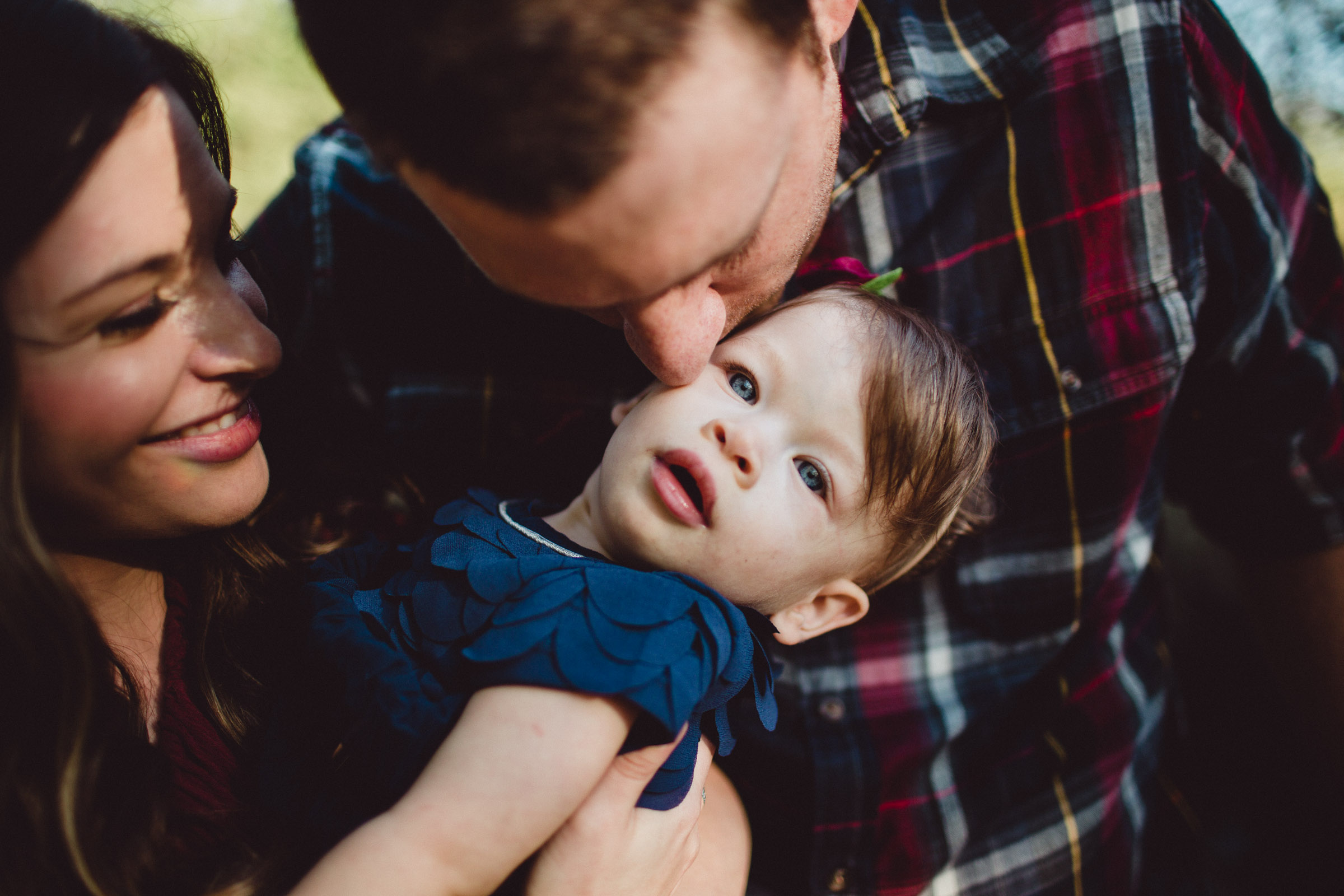 mother and father loving on their youngest 