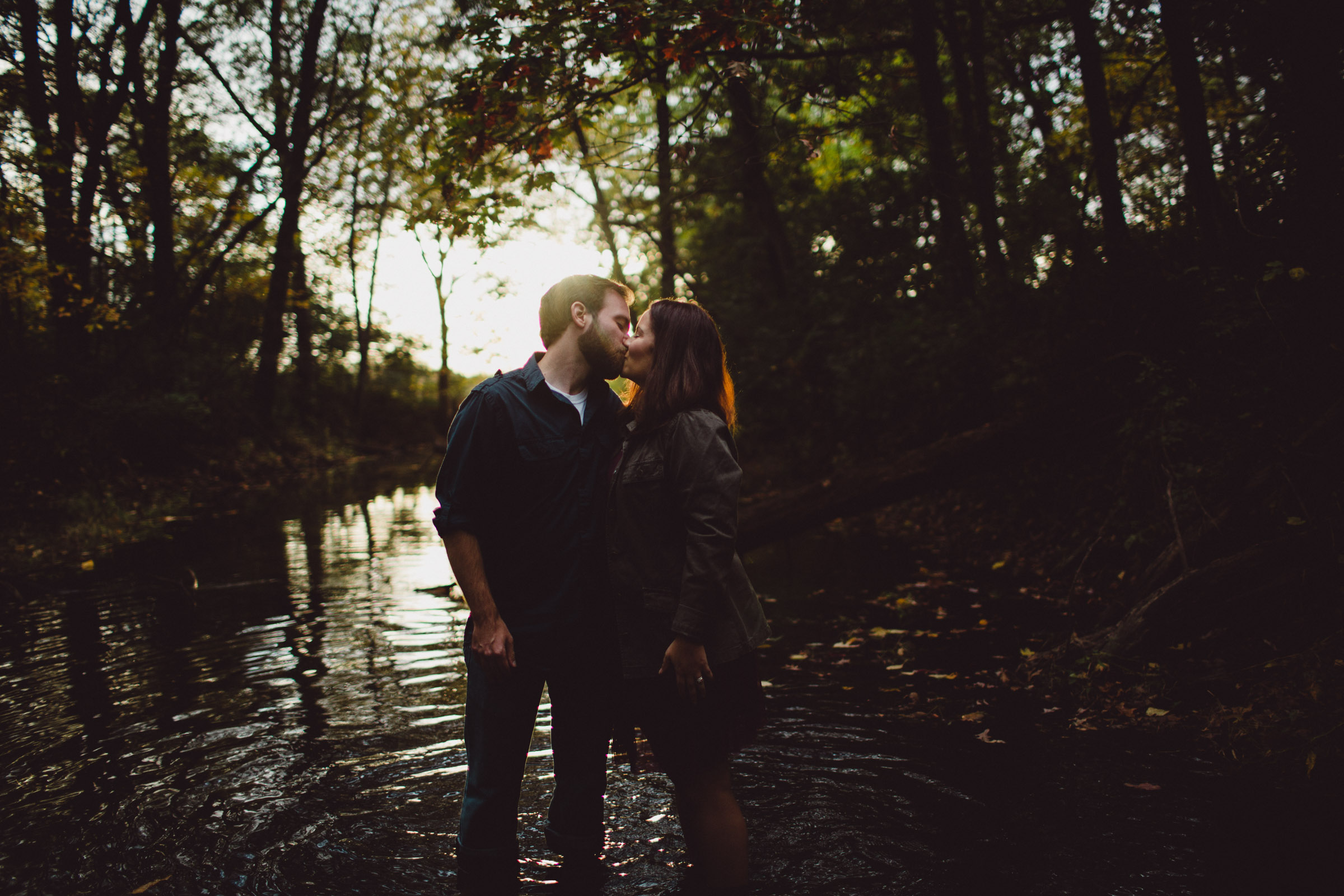 couple kissing in creek with beautiful backlight 