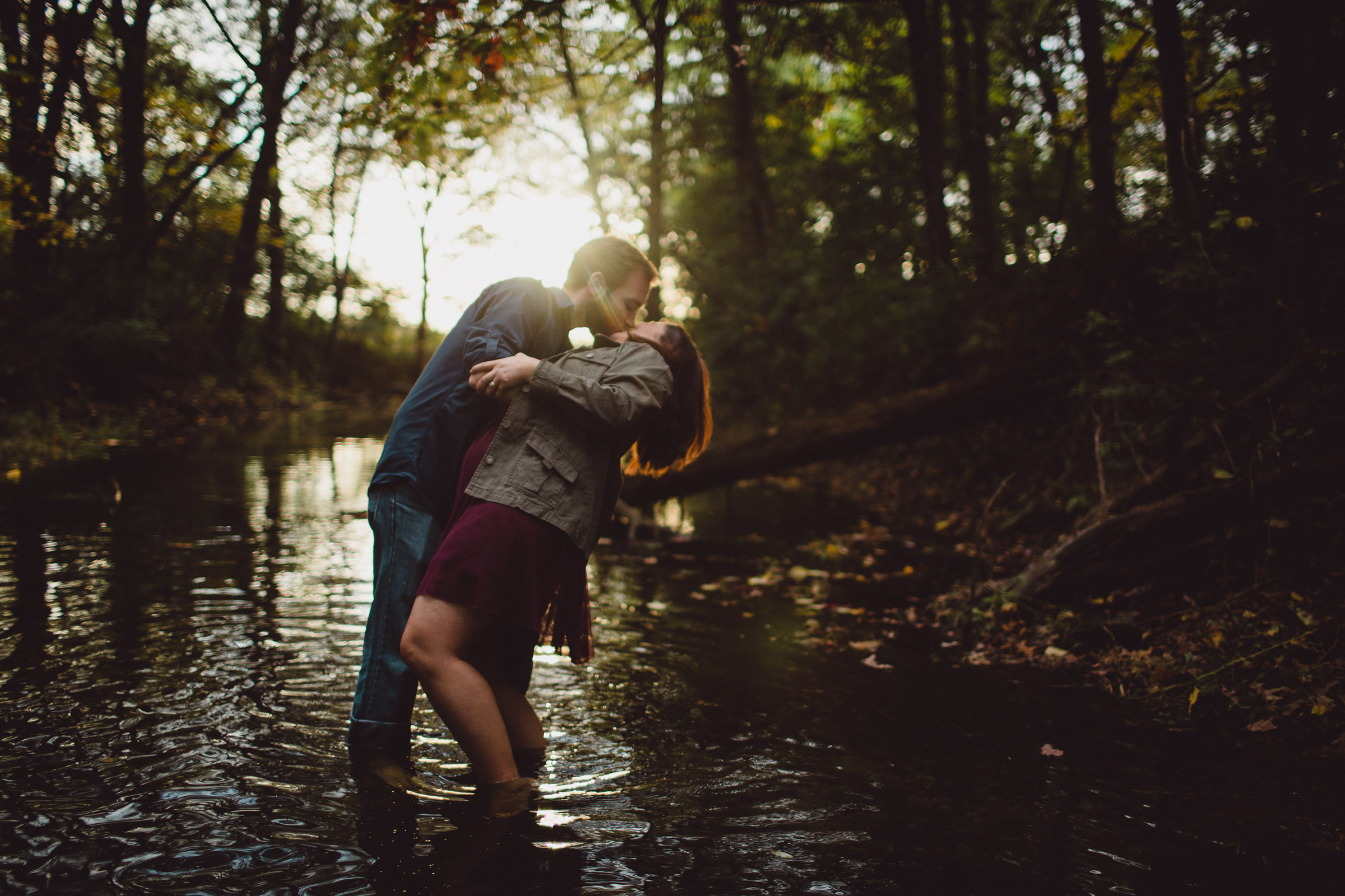 couple kissing while dipped in water with beautiful backlight 