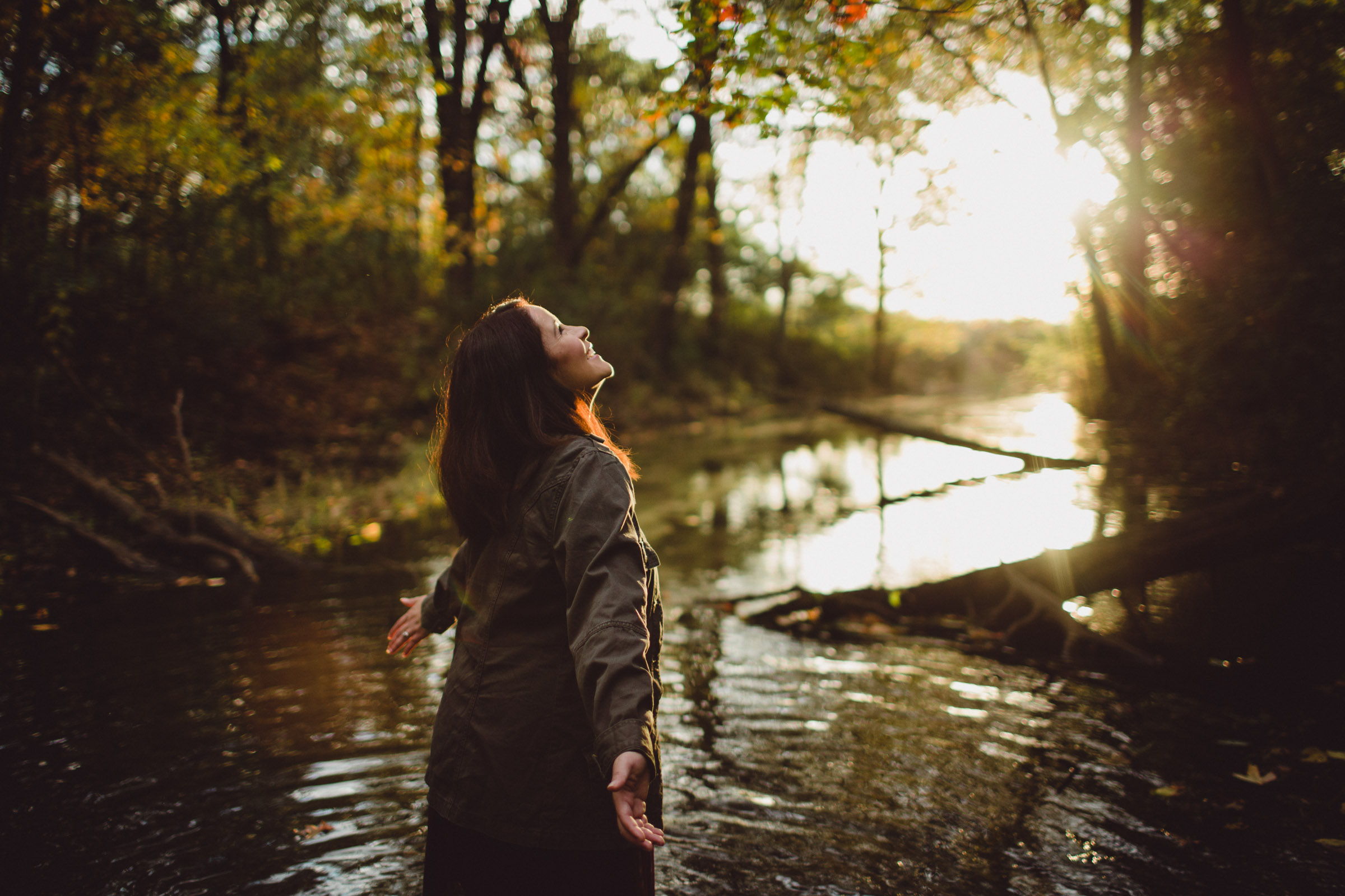 soaking in the joy and sunshine, eyes focused on the light above, girl in creek waters 