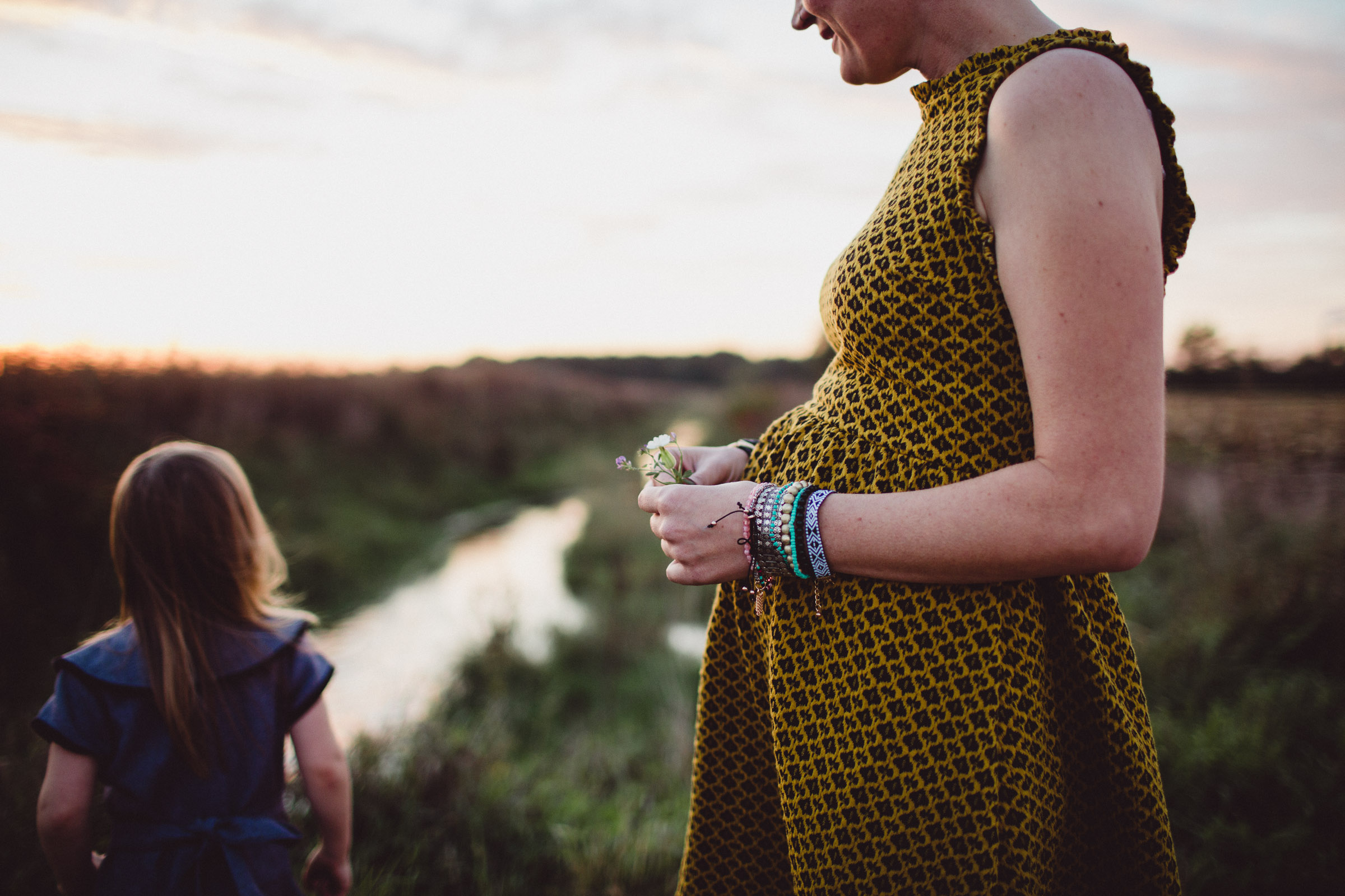 mother holding flowers by river 