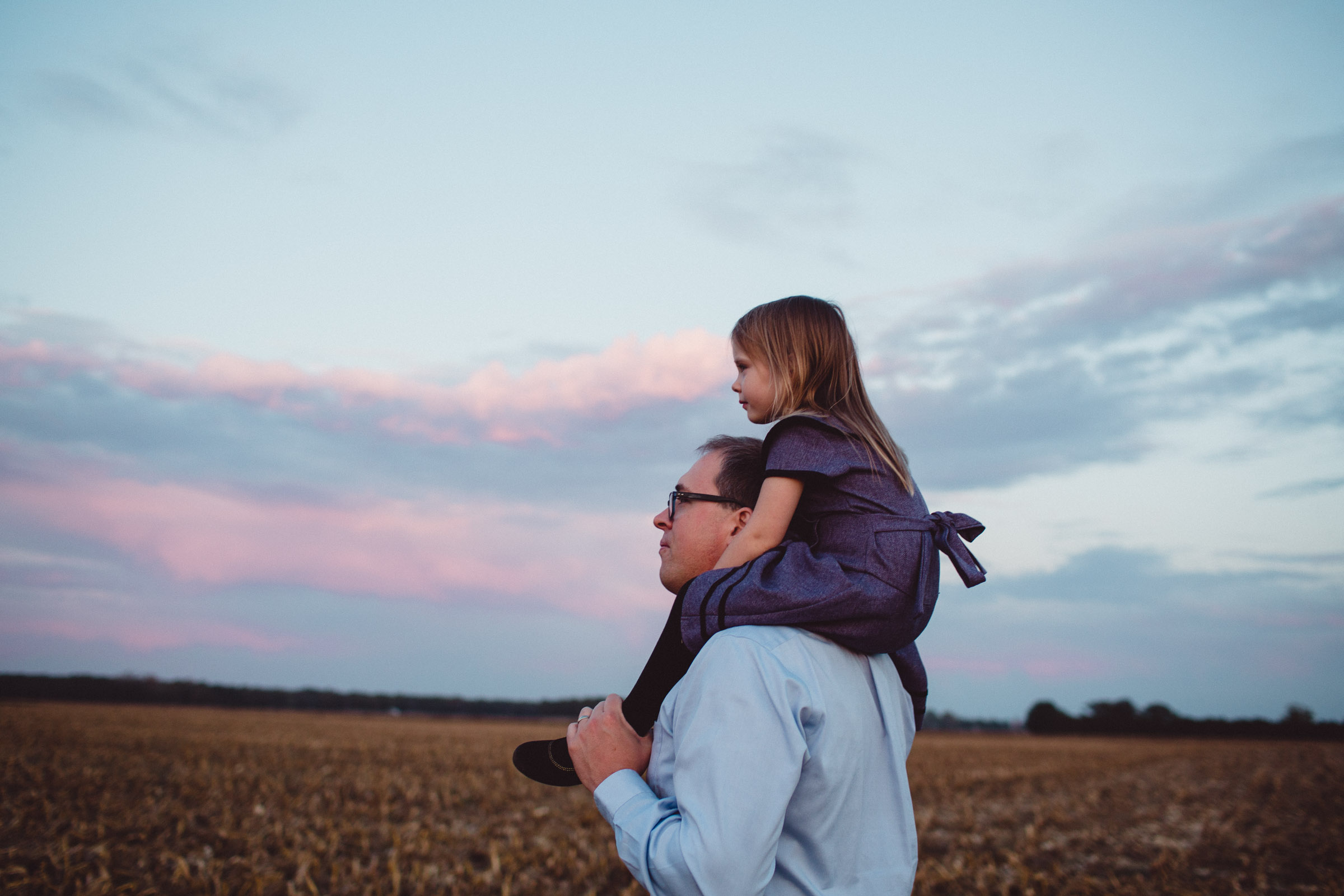 Father walking with daughter one shoulders 