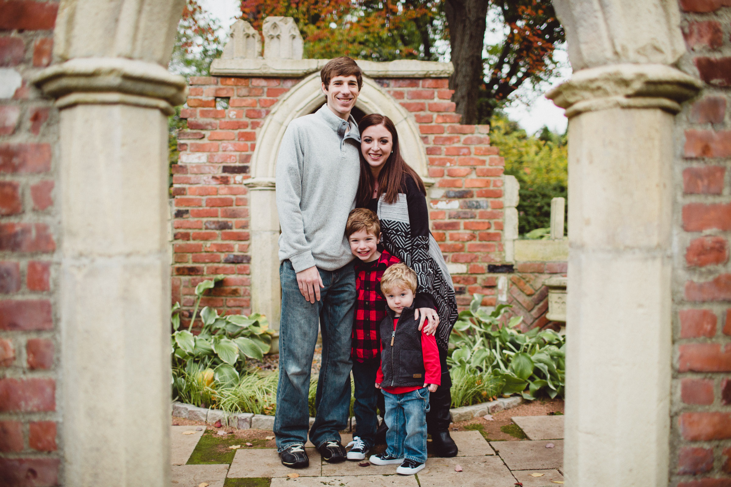 Family snuggles together underneath arch