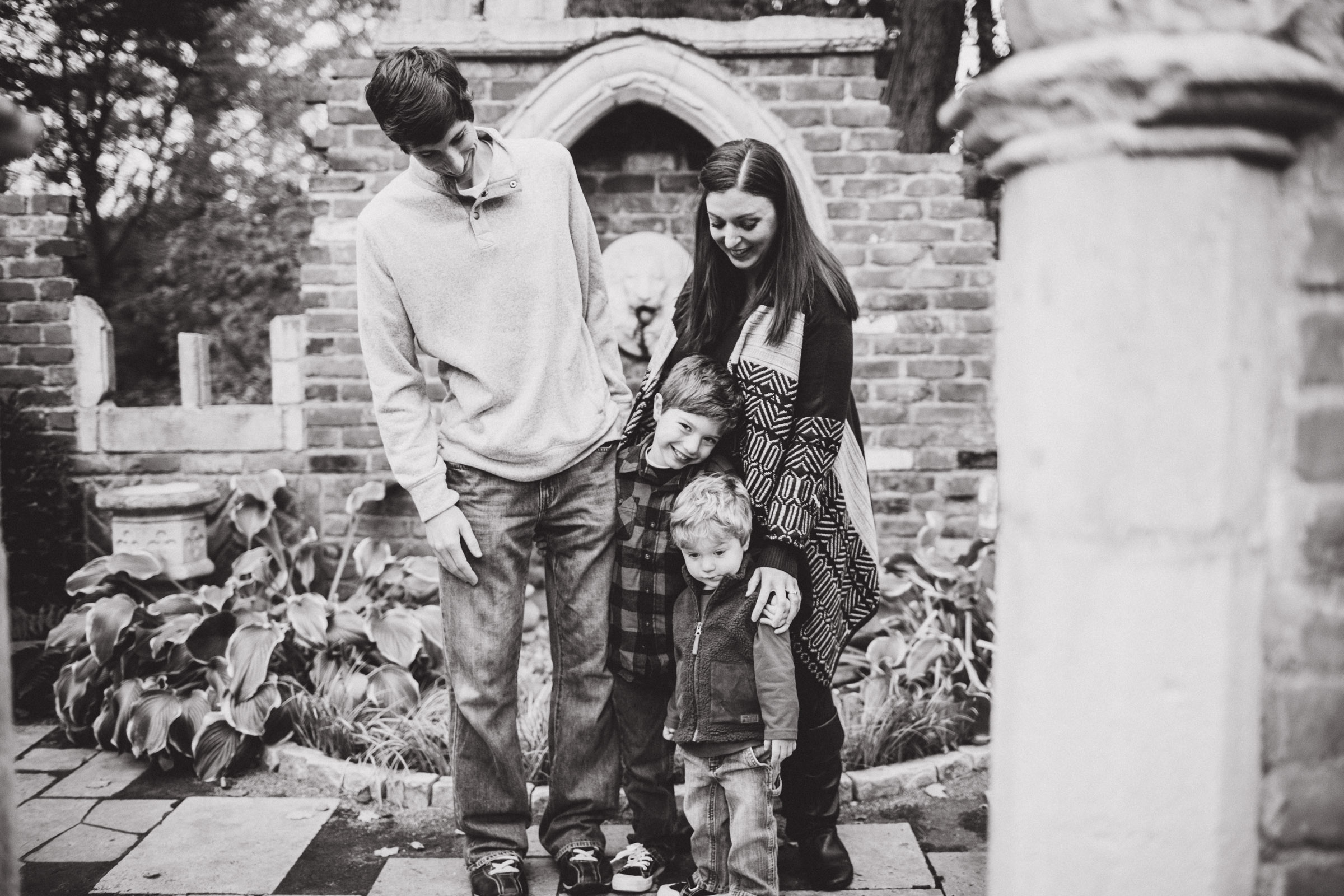 Son smiling underneath mother's legs in a family hug