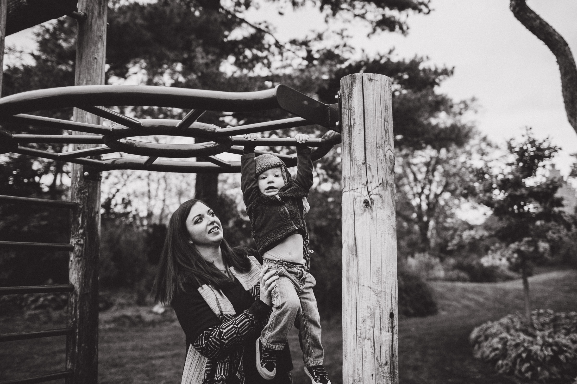 mother helping son across monkey bars