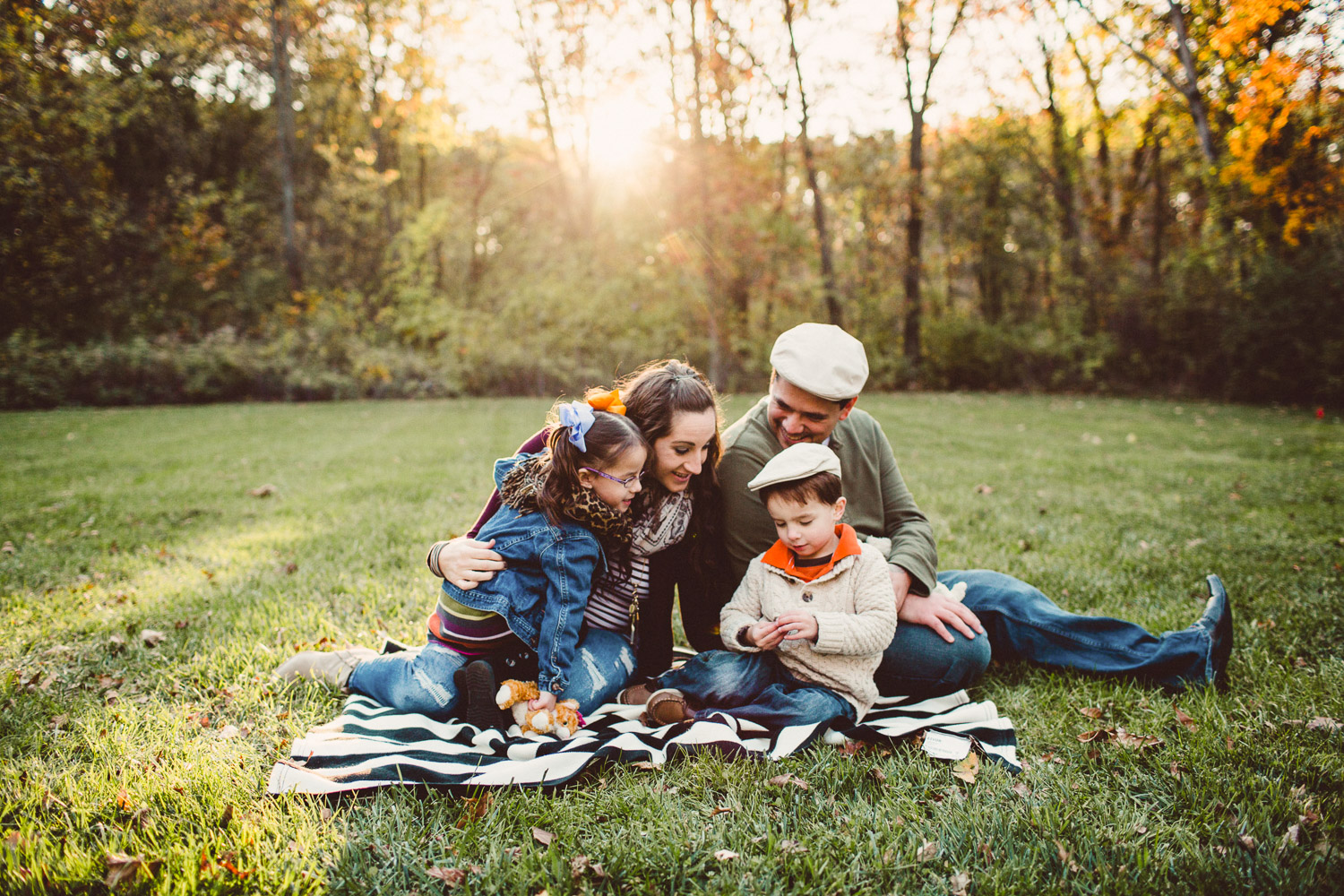 Family cuddled together on blanket with backlight 