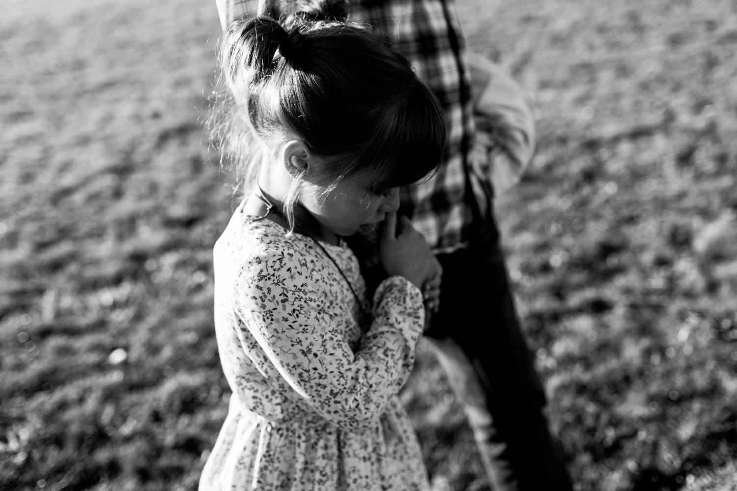 Child walking in embrace of her father, black and white portrait