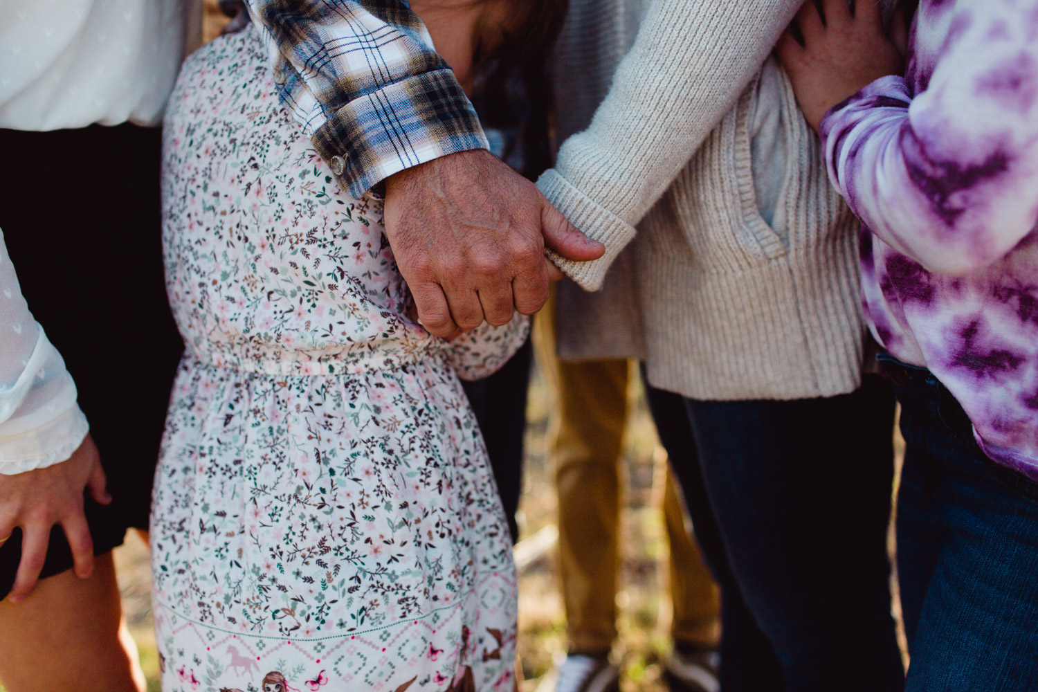 detail image of parents holding hands with children surrounding