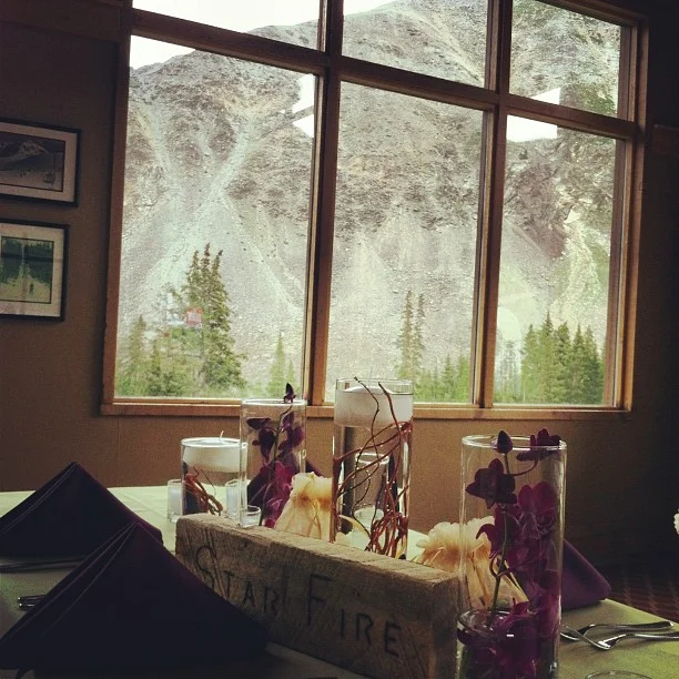 Orchids, curly willow, and floating candles. Tables have names on wood and trail mix are on there as favors.