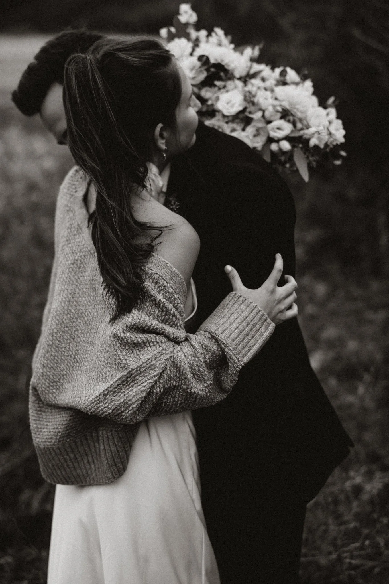 Black & white images of a bride in a dress & chunky sweater hugging her new husband in Breckenridge, CO.