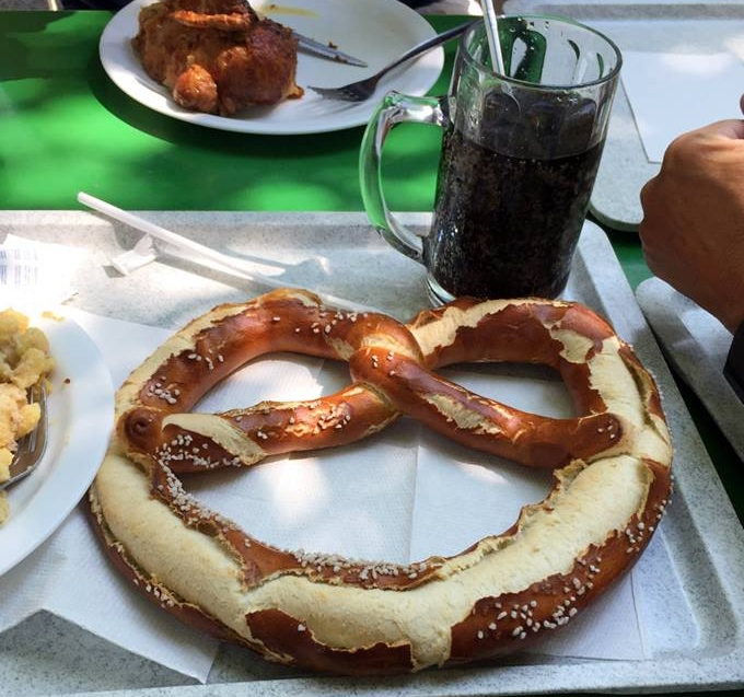 A traditional german soft pretzel and spezi - a cola and orange soda mixture