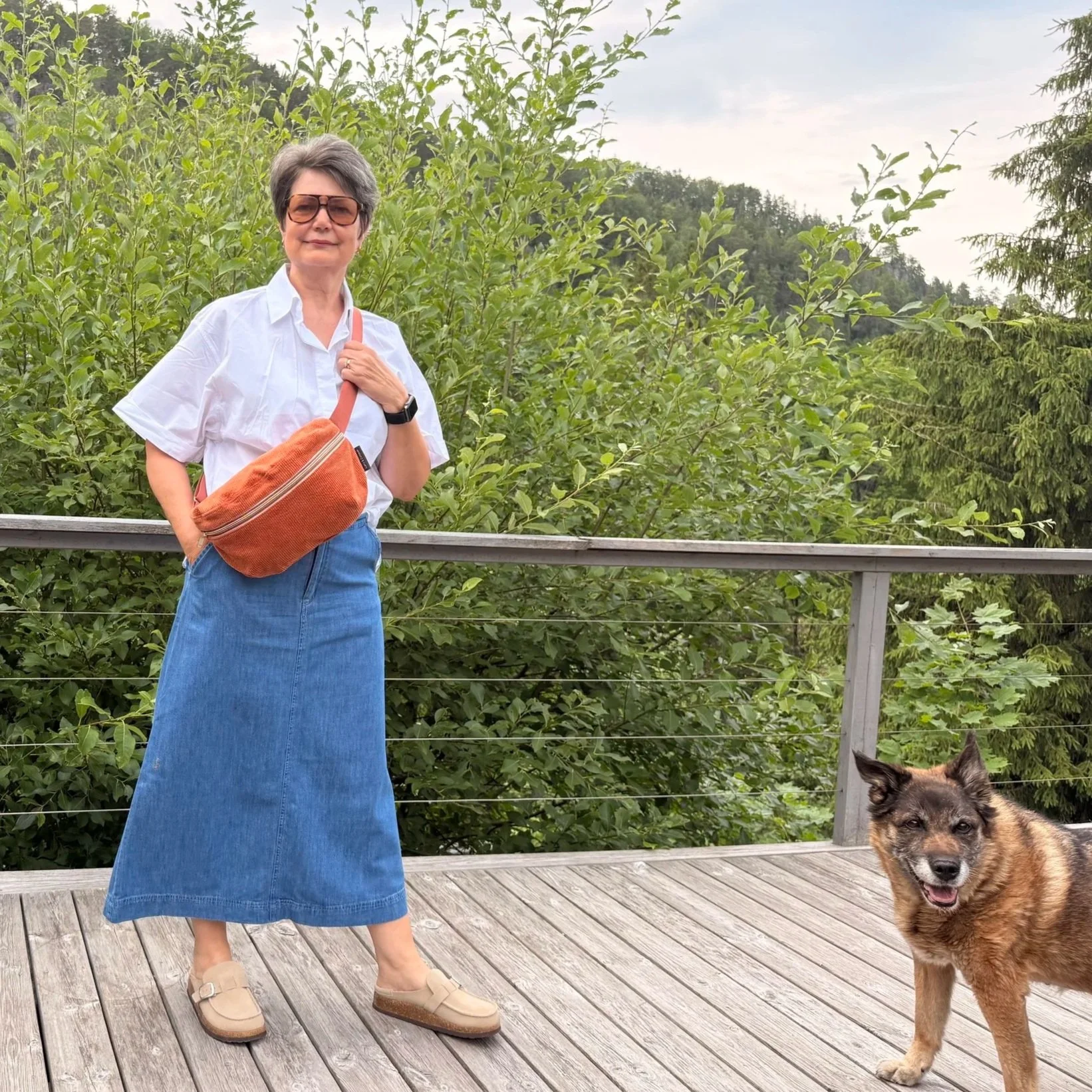 Model wearing an adjustable burnt orange corduroy sling bag across the chest for hands-free travel.