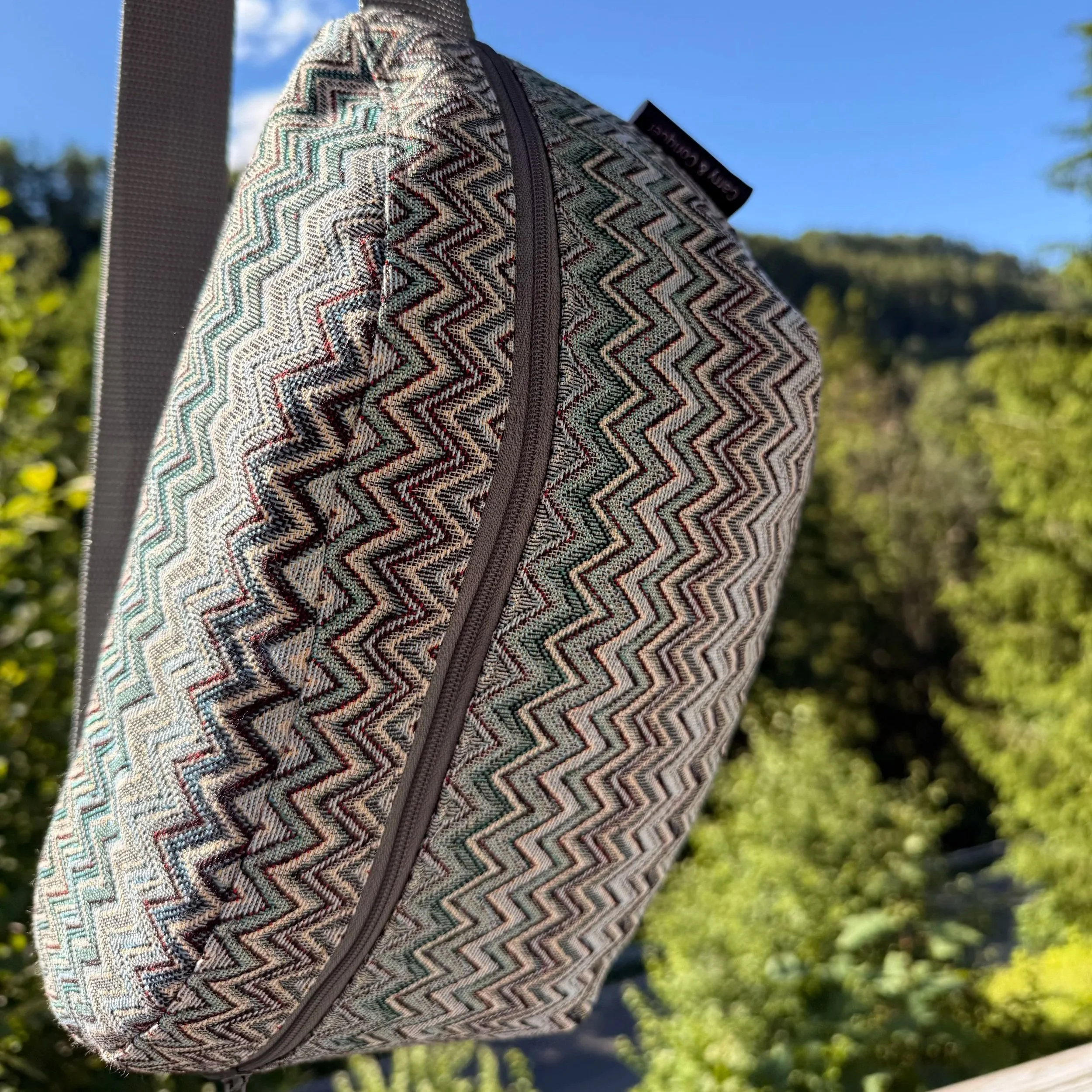 Detailed close-up of the durable woven Gobelin tapestry pattern on a handmade blue and green sling bag.