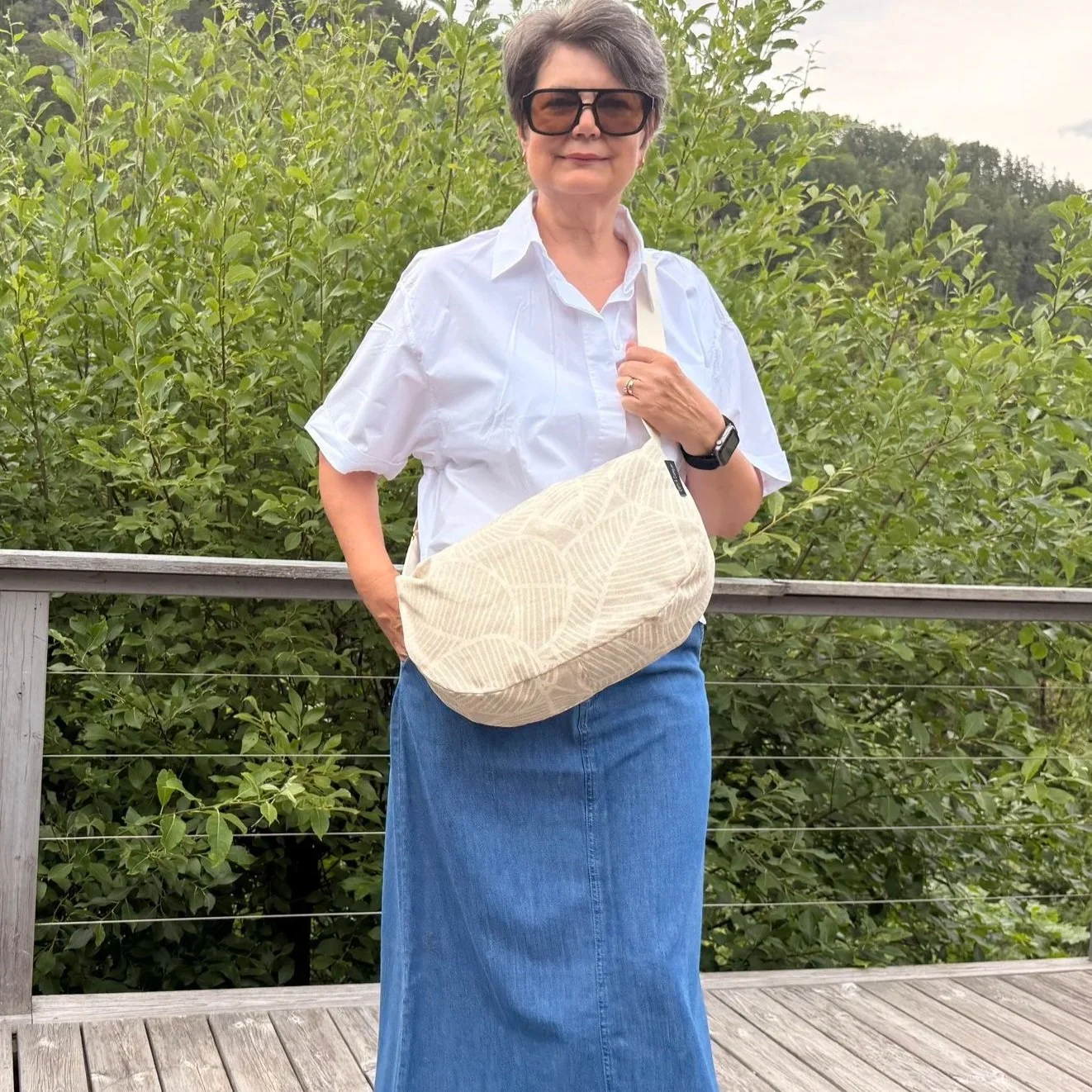 Model wearing an ergonomic sand-beige moon bag showing handsfree option.