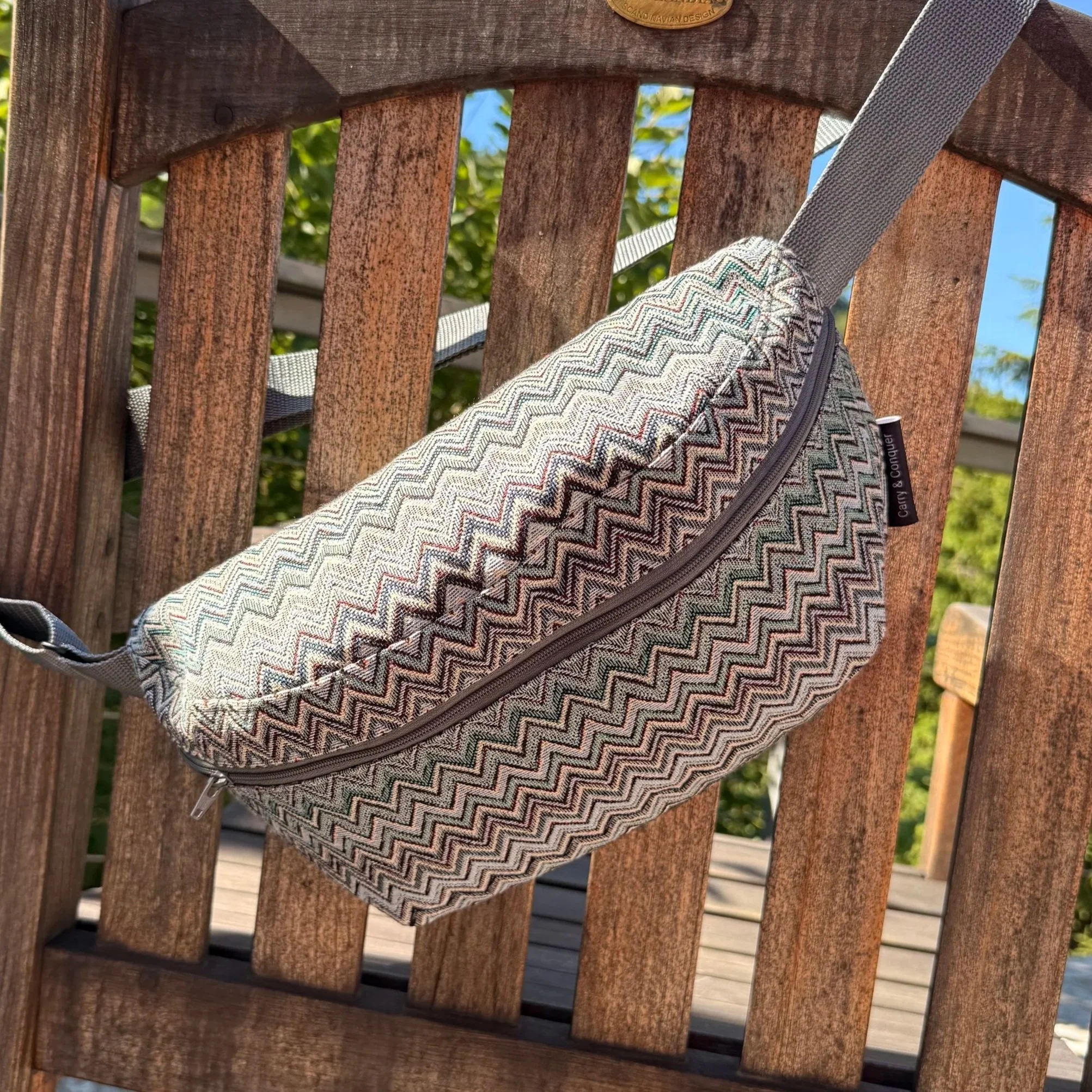 Front view of the Fjord crossbody sling bag showing the blue, grey, and green zig-zag Gobelin fabric.