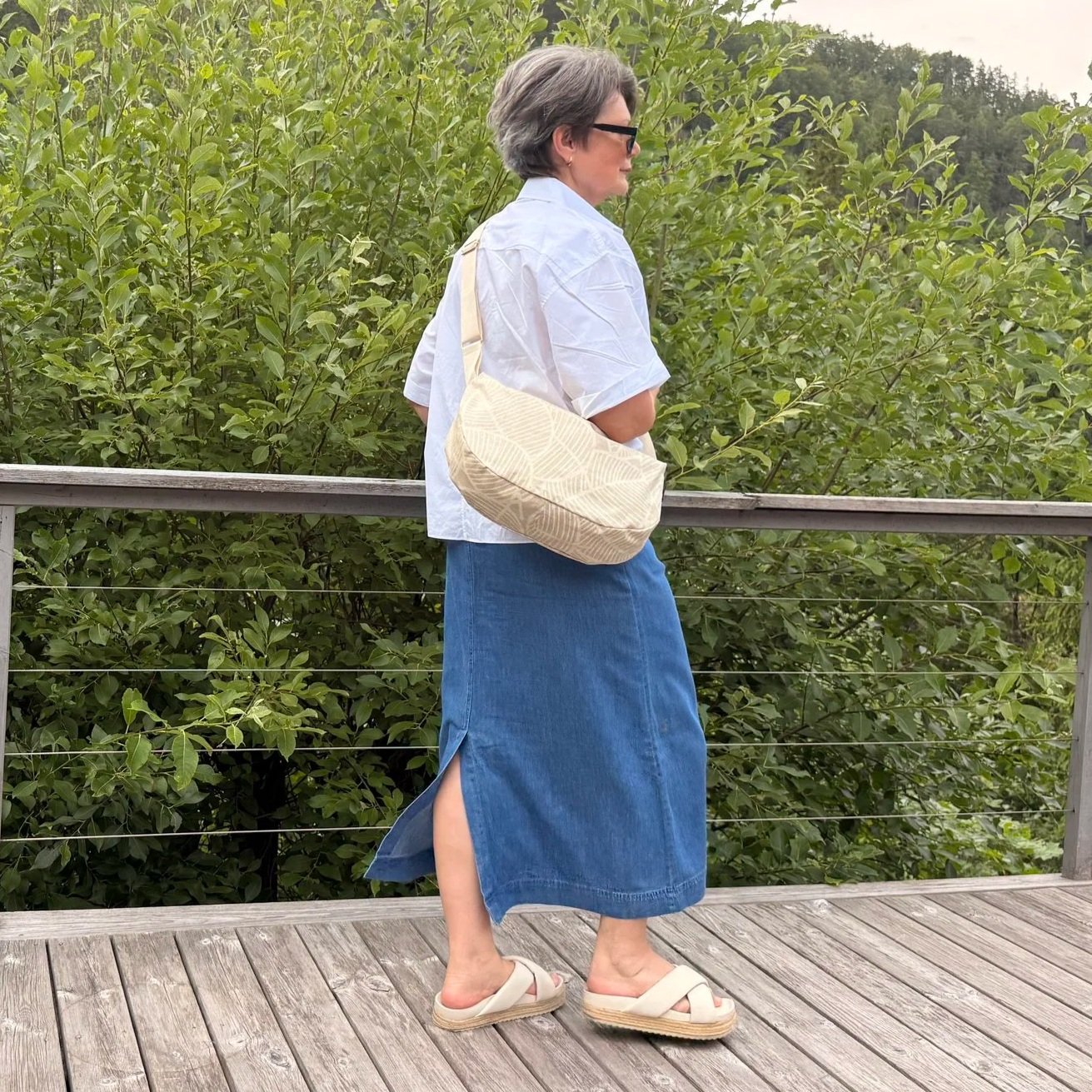 Model wearing an ergonomic sand-beige moon bag on her side.