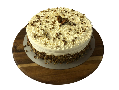 Pastel envinado con cobertura de crema batida y nuez pecana. Hecho artesanalmente en Bislee.