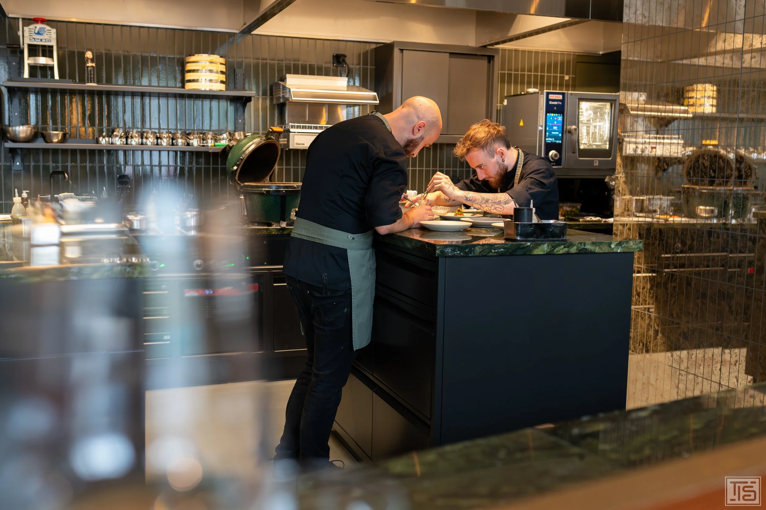 Küchenteam von The Counter Zürich beim Anrichten der Teller in der offenen Küche