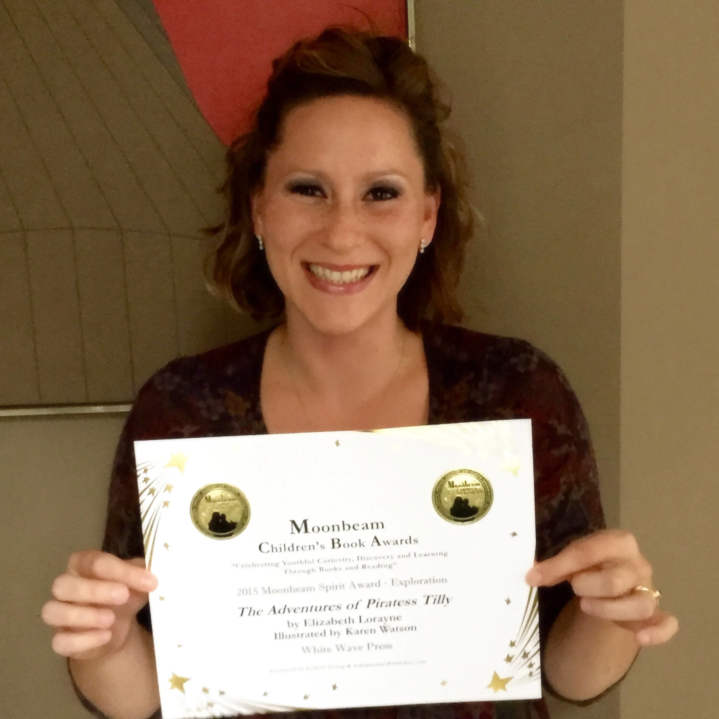 Elizabeth Lorayne holding the 2015 Moonbeam Children's Book Award for the Moonbeam Spirit Award in Exploration certificate