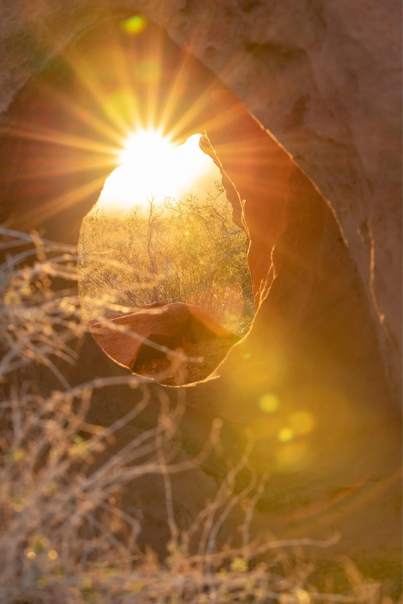 I took this in early November, and loved capturing the sunburst through the hole in the red rocks.