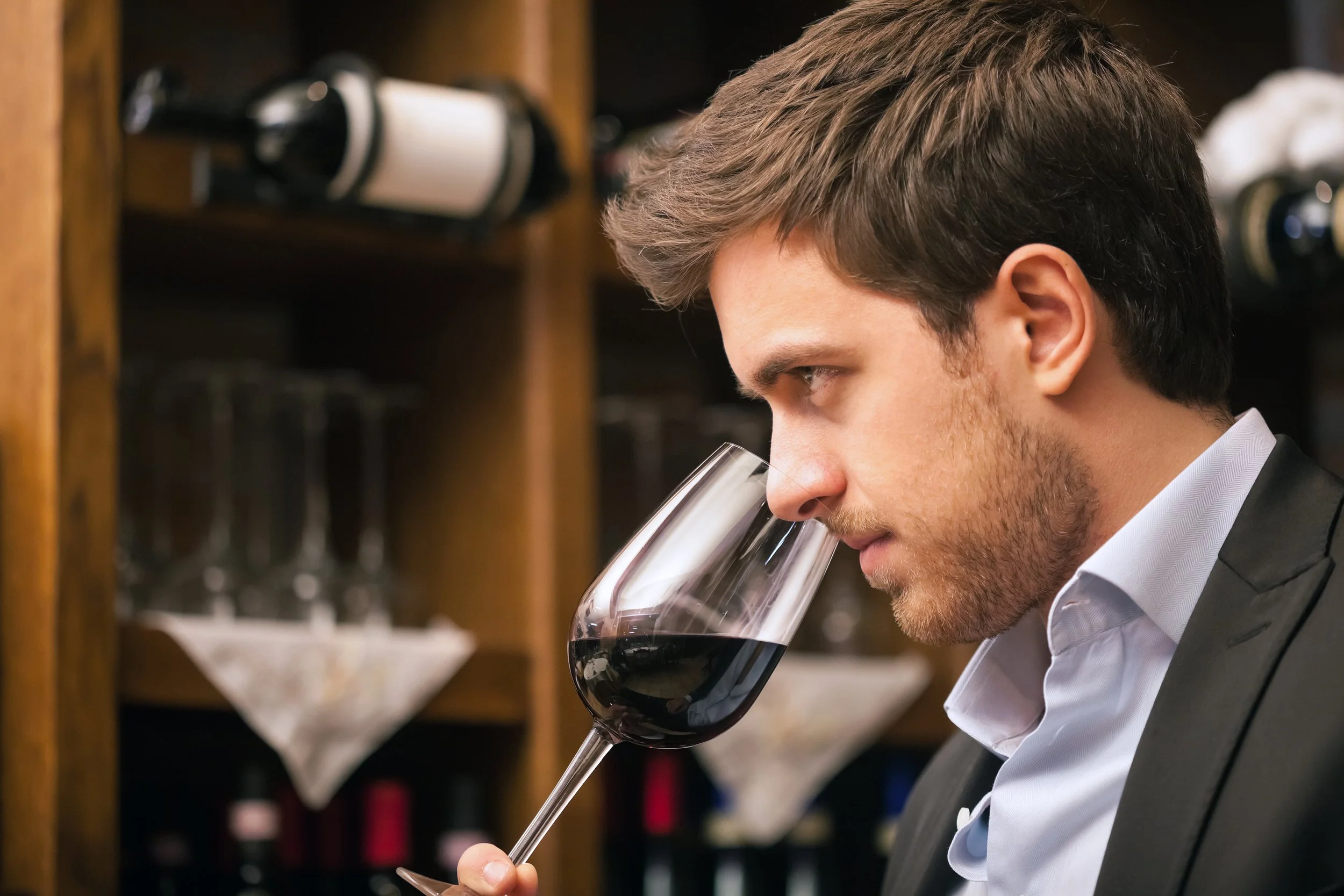 A wine business professional enjoying a glass of red wine while focusing on future business success