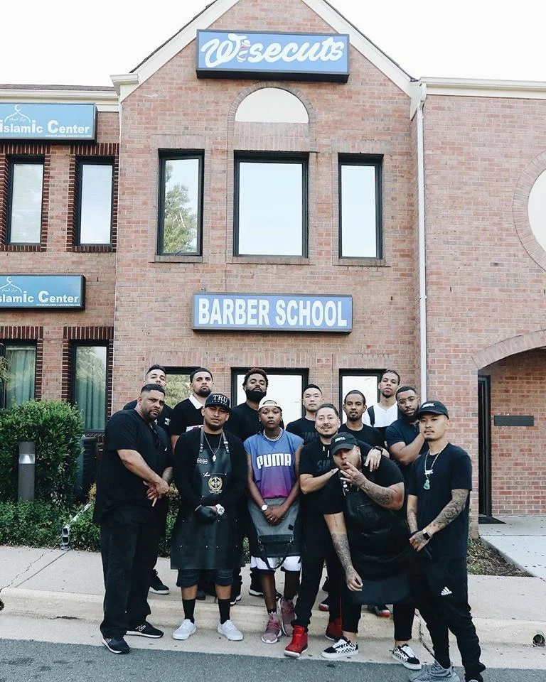 Wisecuts Burke Shop and Barber School team in front of the front entrance and sign