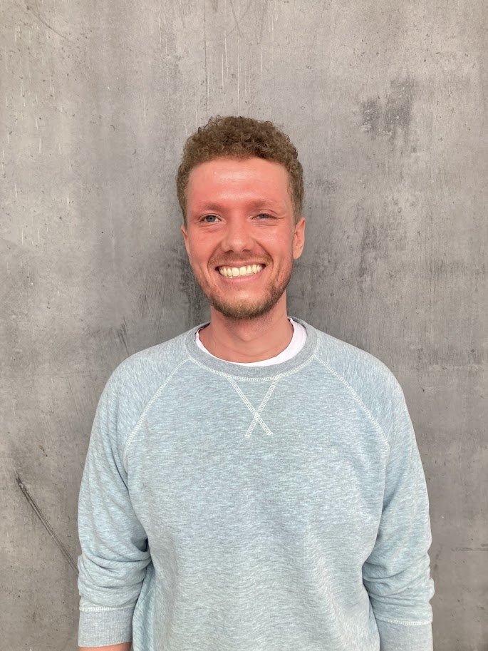 Jovi is een jonge mannelijke psycholoog, met blond haar. Hij draagt een grijze trui, glimlacht en staat voor een grijze muur in Gent.